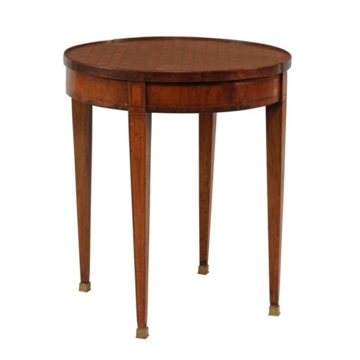 A French round parquetry top game table with flip top and tapered legs from the second half of the 19th century. This French table features a circular parquetry top that flips to reveal a green felt lined side perfect for a game table use. The table is raised on four slender tapered legs, each accented with a delicate inlaid banding of lighter color. The legs rest on brass feet. With its lovely top and elegant classical lines, this French 1870s table will bring a stylish touch to any home.