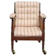 An English mahogany armchair with striped upholstery, on casters. It's from the 19th century.